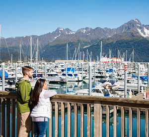 Couple looking at boats on the water in Seward. Photo by Glenn Aronwits.